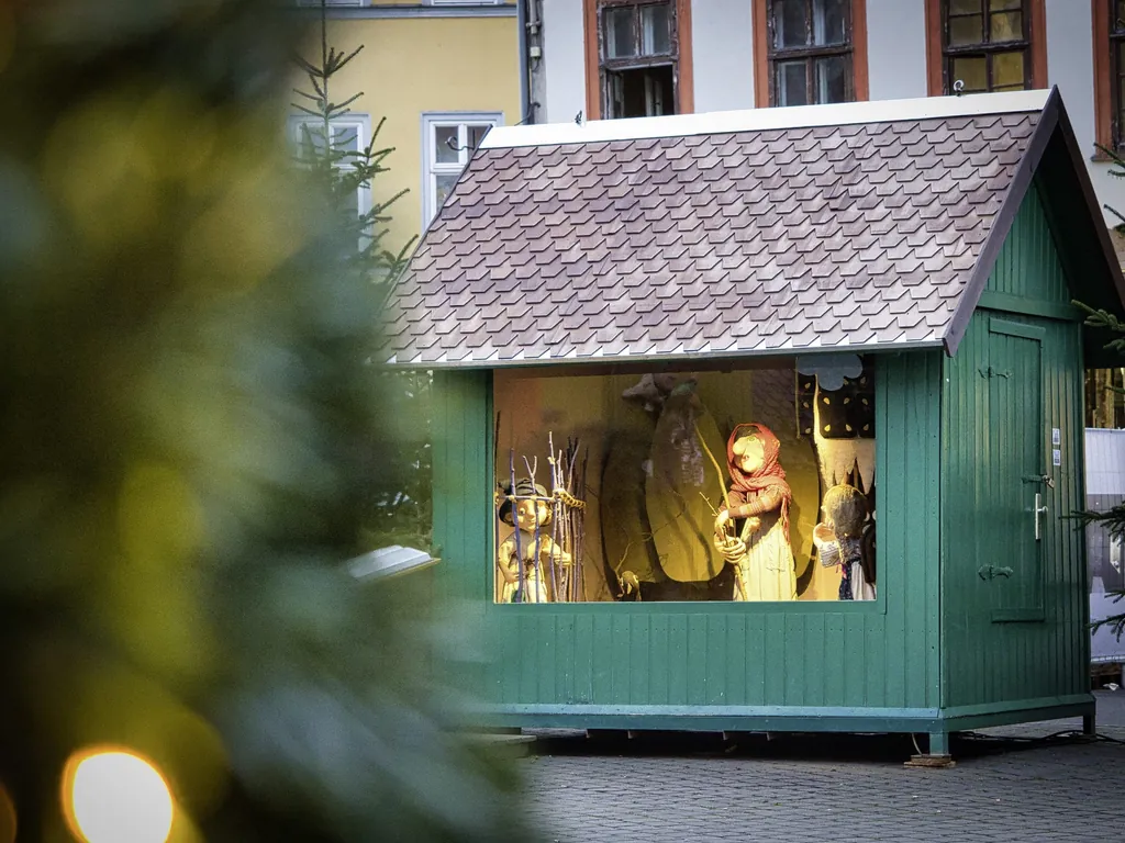 Kleine, gr&uuml;ne Holzh&uuml;tte mit M&auml;rchenfiguren im M&auml;rchenwald auf dem Erfurter Weihnachtsmarkt