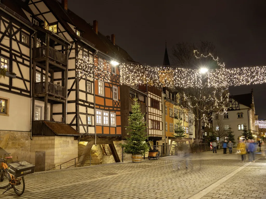 Fachwerkh&auml;user in der Erfurter Altstadt mit abendlicher Weihnachtsbeleuchtung und gepflastertem Weg
