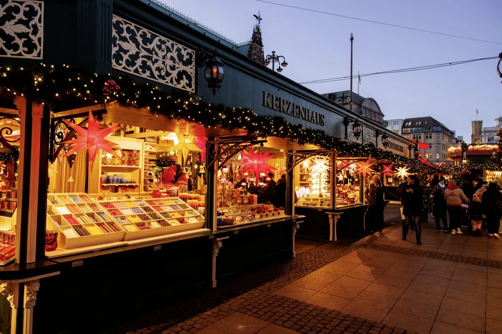 Kerzenhaus-Stand auf dem Hamburger Weihnachtsmarkt mit verschieden farbigen Kerzen und festlicher Beleuchtung