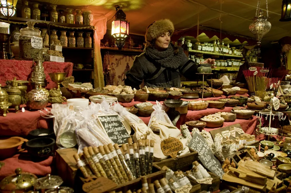 Verk&auml;uferin mit Pelzm&uuml;tze steht hinter ihrem Stand mit vielen Kr&auml;utern, Gew&uuml;rzen, Weihrauch und R&auml;ucherst&auml;bchen auf dem Schlachte-Zauber in Bremen