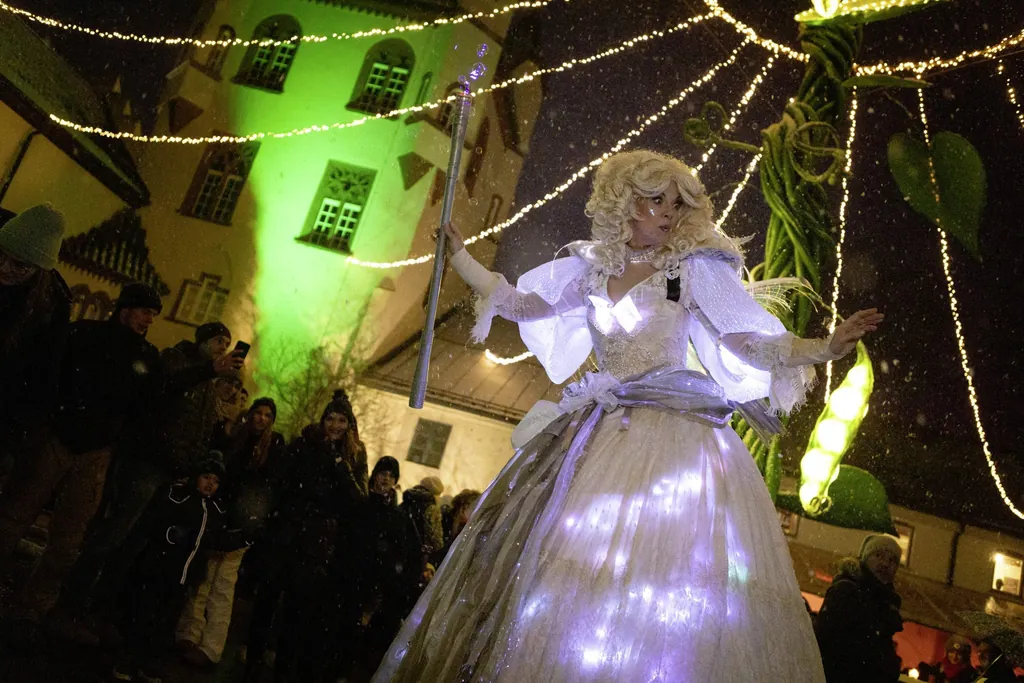 kost&uuml;mierte Frau in einem wei&szlig;en, leuchtenden Kleid mit blonden Locken und Stab in der Hand auf dem Weihnachtsmarkt des Schloss Kaltenberg