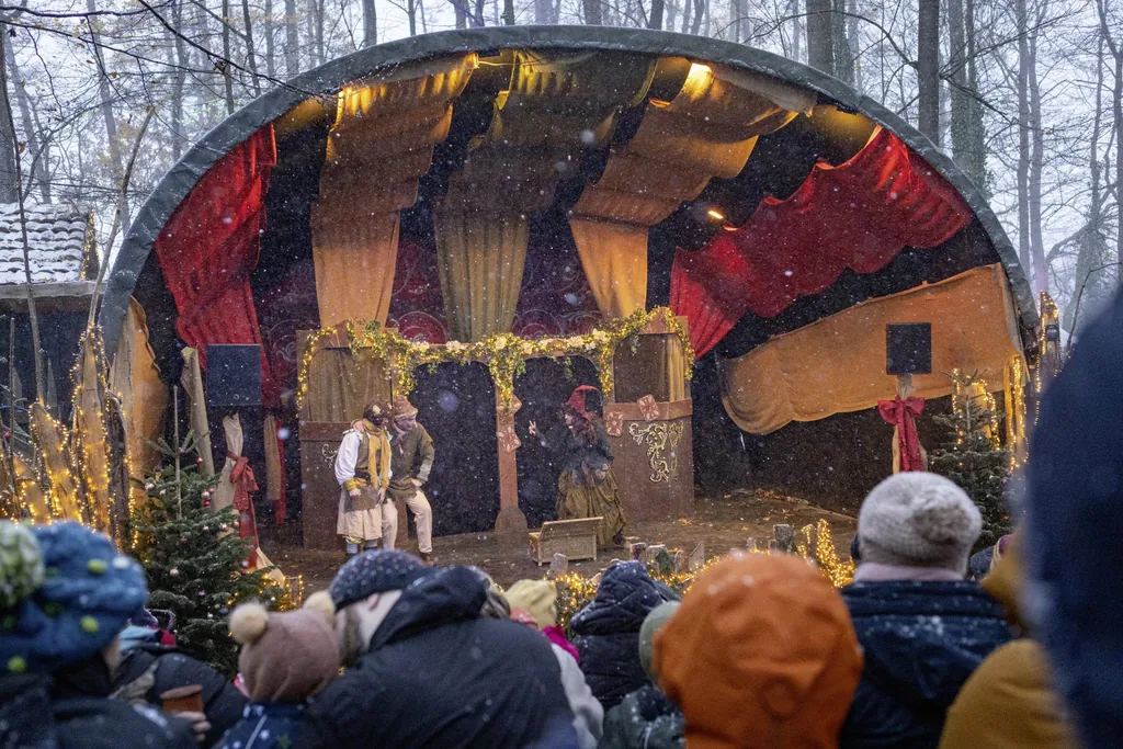 Blick auf die weihnachtlich geschm&uuml;ckte M&auml;rchenb&uuml;hne des Weihnachtsmarktes auf Schloss Kaltenberg mit drei Schauspielern