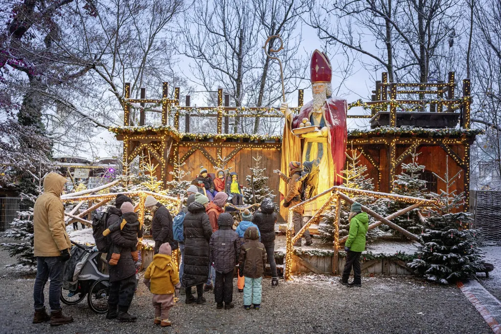 Besucher stehen vor riesiger Nikolausfigur auf dem Weihnachtsmarkt des Schloss Kaltenberg