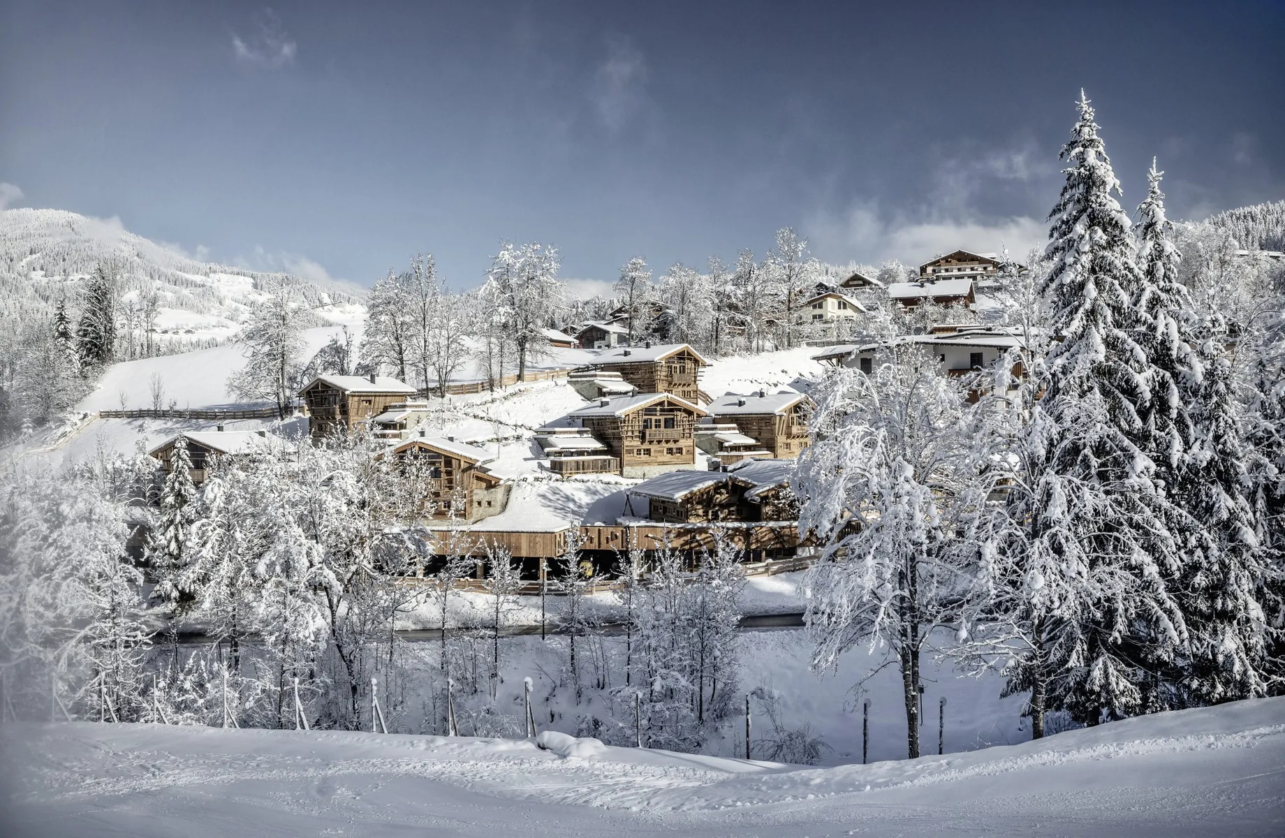Blick auf die Chalethütten des Bergdorf Prechtlgut inmitten verschneiter Winterlandschaft