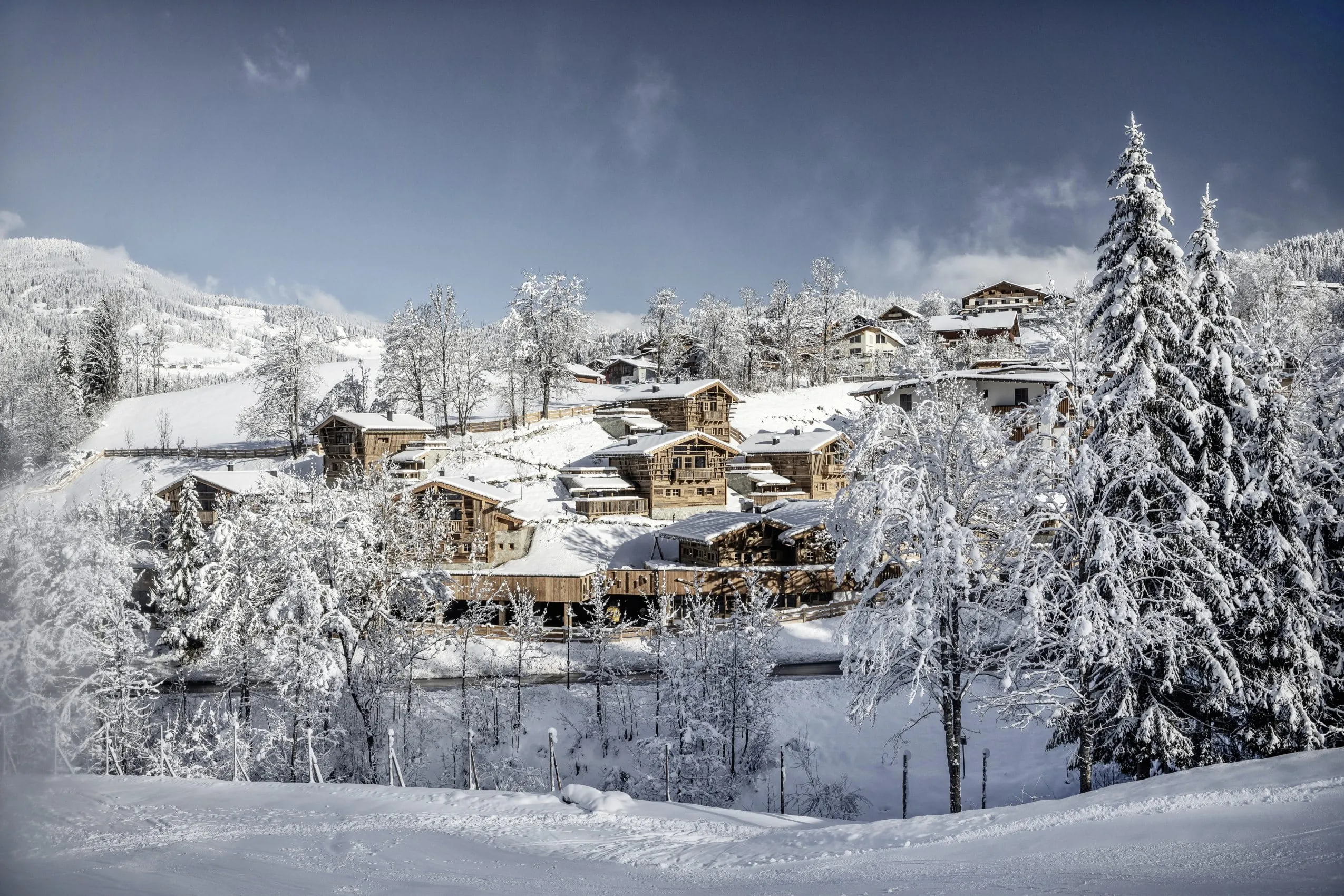 Blick auf die Chalethütten des Bergdorf Prechtlgut inmitten verschneiter Winterlandschaft