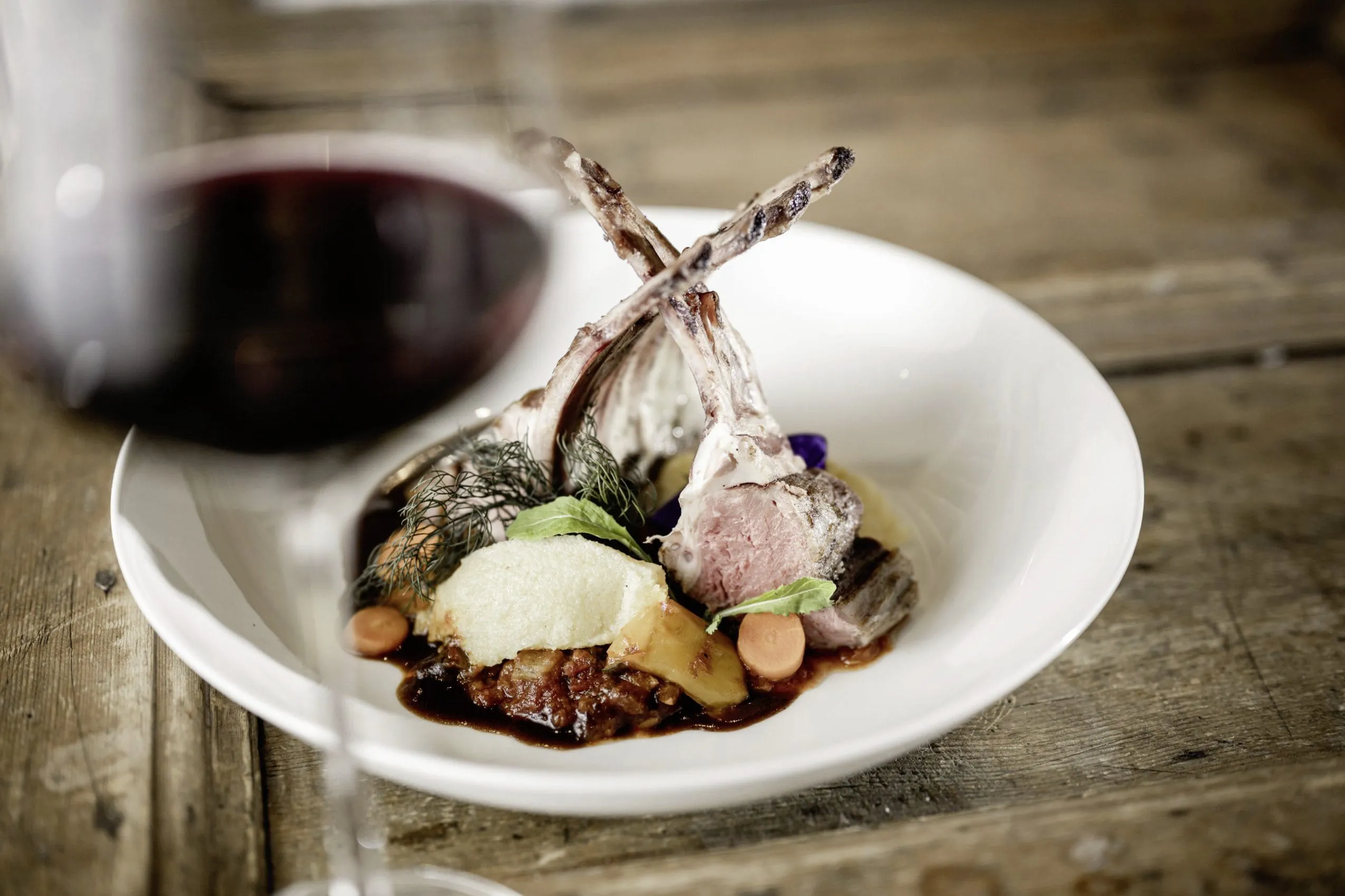 Wundersch&ouml;n angerichtetes Teller mit Wildfleisch noch am Knochen, regionalem Gem&uuml;se, Kartoffelstampf und dunkler So&szlig;e.