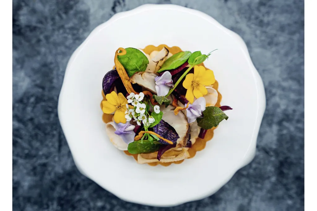 Bl&uuml;tengericht auf wei&szlig;em Teller im Hotel mit Sternek&uuml;che Trofana-Royal