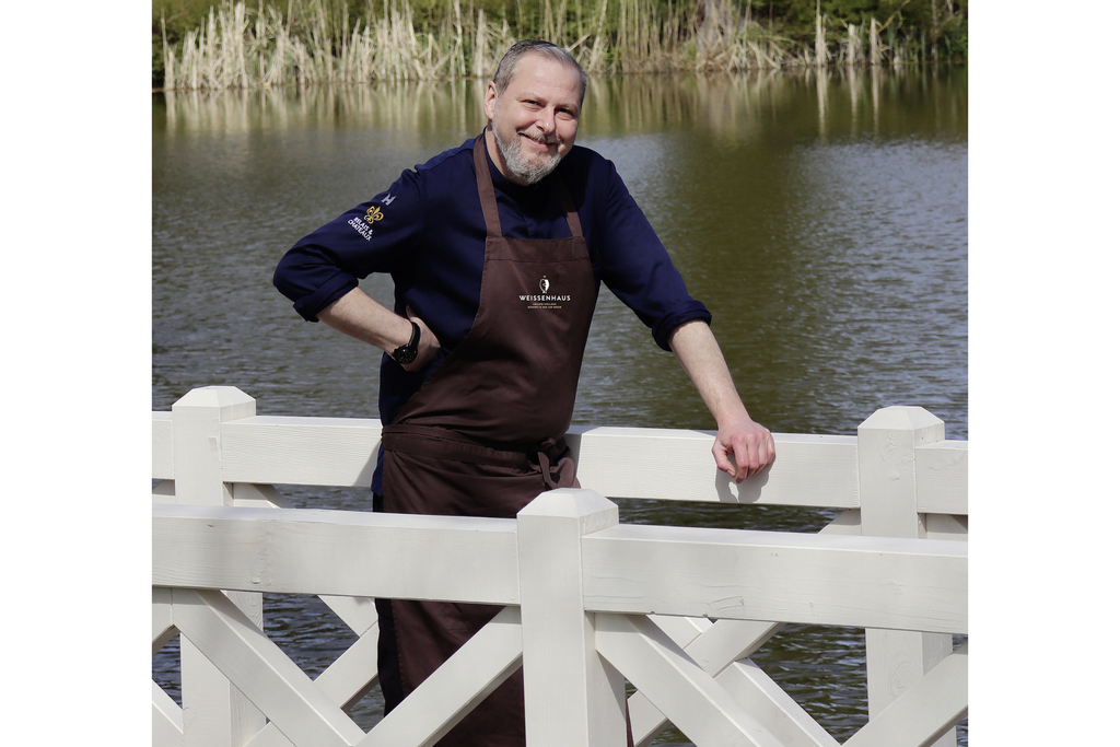Christian Scharrer auf dem Steg vor dem Teich des Weissenhaus Grand Village Resort & Spa am Meer