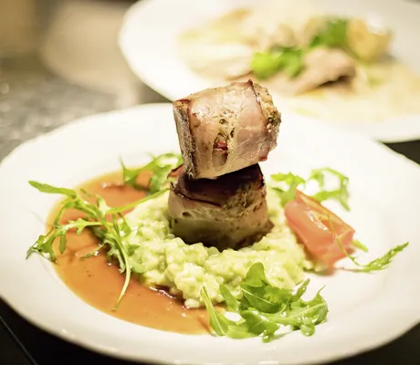 Fleischgericht auf weißem Teller im Gartenhotel Magdalena