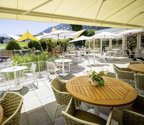 Terrasse im Gartenhotel Magdalena mit Blick auf den Naturteich und die gelben Sonnenschirme