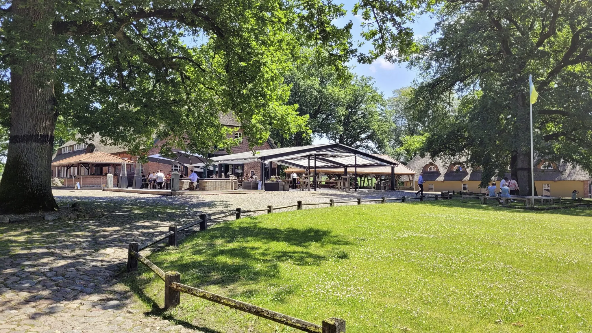 Hofambiente im Gut Thansen mit überdachtem Outdoorbereich und reetgedeckter Scheune
