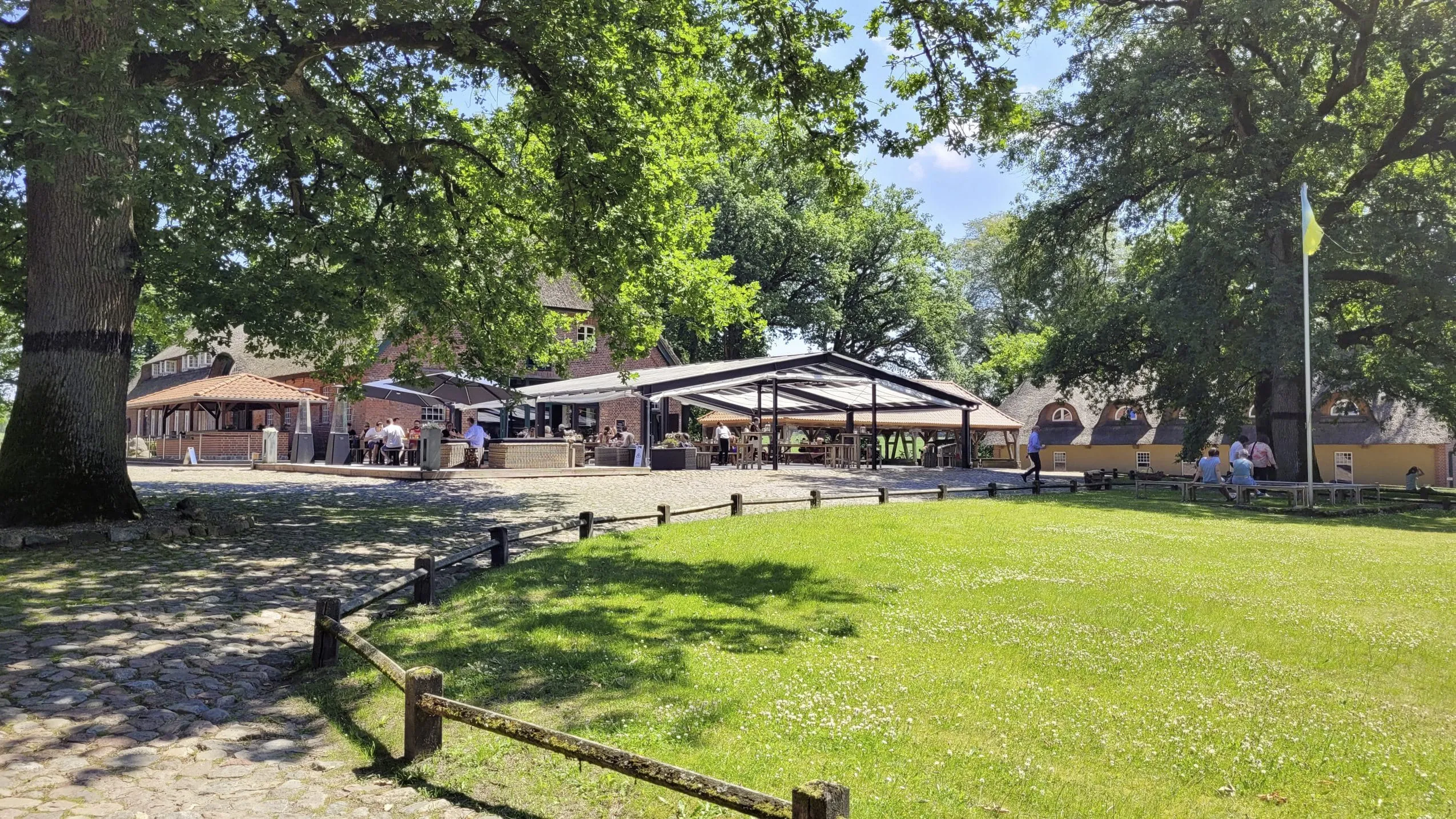 Hofambiente im Gut Thansen mit überdachtem Outdoorbereich und reetgedeckter Scheune