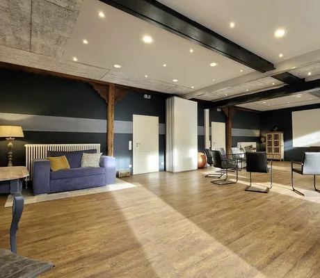 Tagungsraum im Gut Thansen mit Stuhlkreis und blauem Sofa auf Holzboden