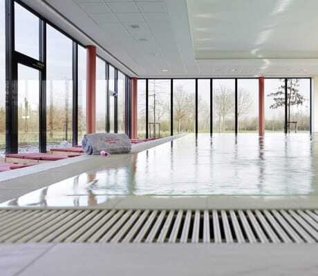 Indoorpool im See Park Janssen mit roten Säulen und grauem aufgerolltem Handtuch