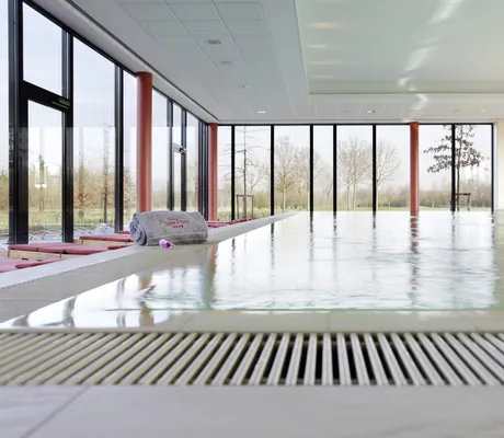 Indoorpool im See Park Janssen mit roten Säulen und grauem aufgerolltem Handtuch