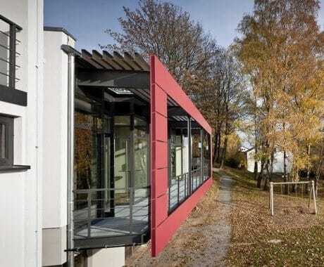 moderner Anbau mit rotem großen Fensterrahmen im Seminarzentrum Rückersbach im Herbst