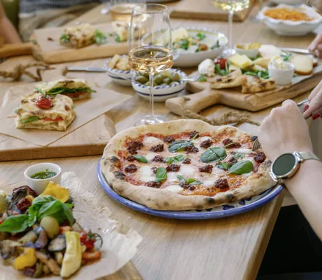 Pizza und mediterranes Gemüse auf Holztisch im A-ROSA Lago di Garda