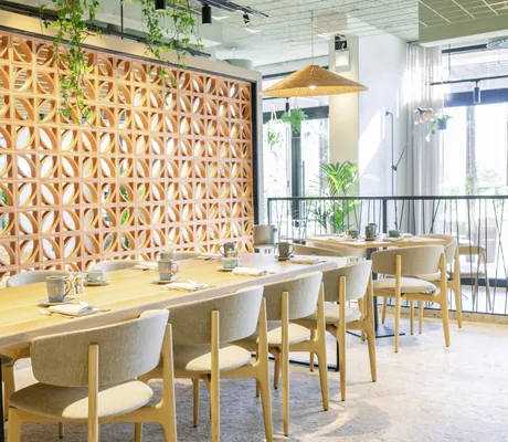 langer Frühstückstisch im A-ROSA Lago di Garda mit verschnörkelter Holzwand