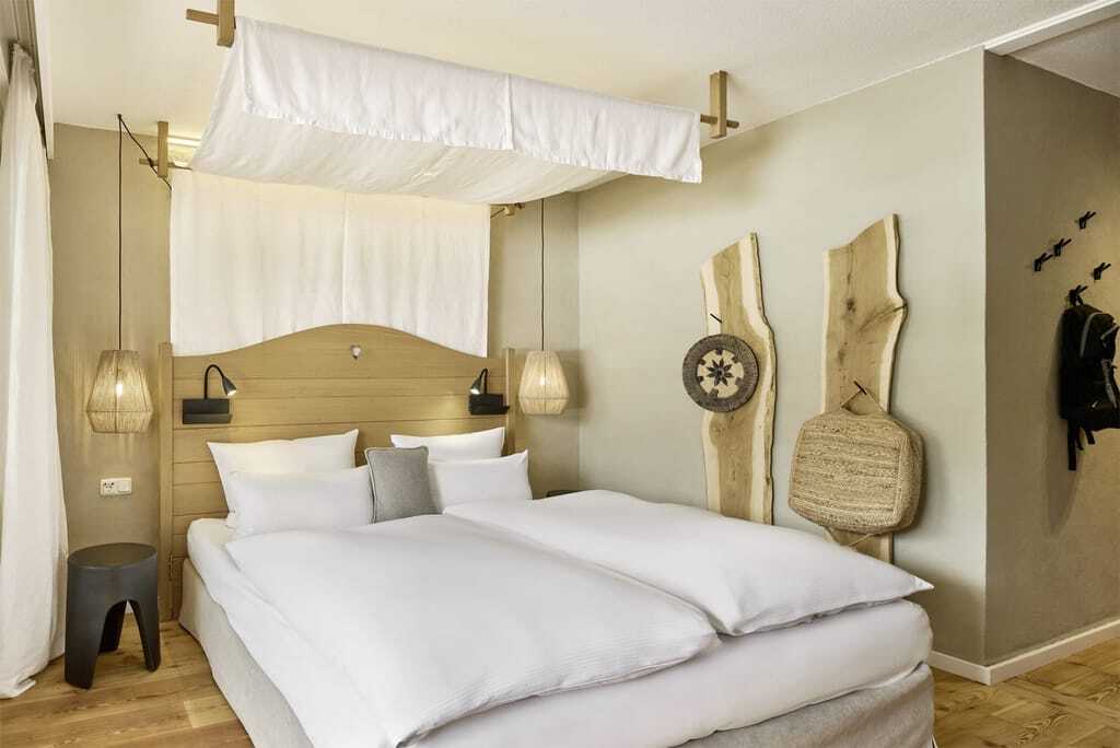 Stilvolles Doppelzimmer Gamsnest mit Boxspringbett und Himmelbett im Wellnesshotel HUBERTUS Mountain Refugio Allgäu