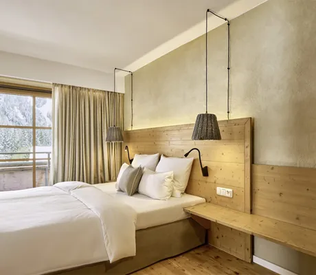 Stilvolles Doppelzimmer im Allgäuer Wellnesshotel HUBERTUS mit Lehmwänden und Holzelementen