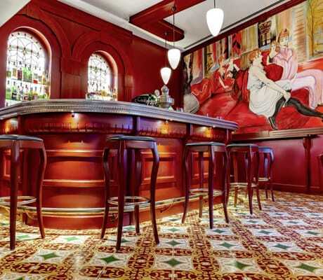 rutbraune Bar mit hohen Barhockern vor Jugendstilbild im Jugendstilhotel Bellevue