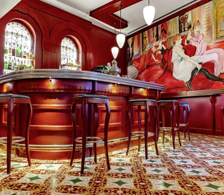 rutbraune Bar mit hohen Barhockern vor Jugendstilbild im Jugendstilhotel Bellevue
