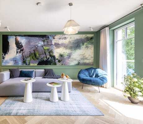 Wohnraum im Palais Kayser des Jugendstilhotel Bellevue mit blauem flauschigen Sessel und großen Ölgemälde