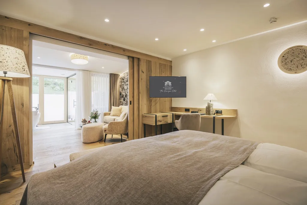 Naturzimmer im Hotel Klosterbräu mit Leinen-Bettüberwurf und Blick in das Badezimmer mit freistehender Badewanne