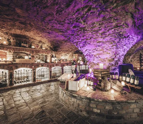 violett beleuchtetes Weingewölbe im Hotel Klosterbräu mit exklusiven Weinflaschen