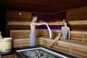 Paar mit Handtüchern umgewickelt entspannt in einer Sauna des Wellness & Naturresort Reischlhof