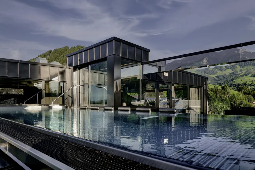 Outdoorpool mit Whirlliegen und Blick auf Dachkonstruktion von die Hochkönigin