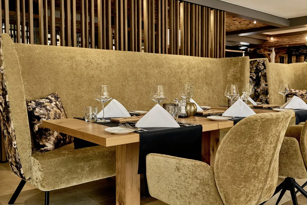 eingedeckter Tisch im die Hochkönigin mit goldenen Samtsesseln und Sofa