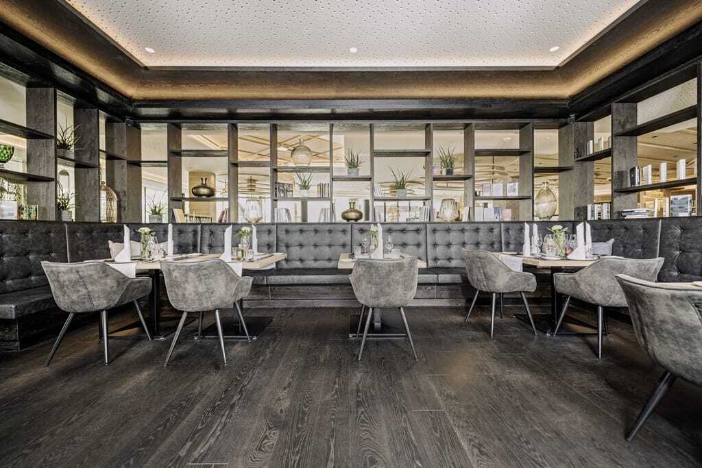Modern und chic eingerichtetes Restaurant des Tiroler Welnesshotels Alpenresort Schwarz in gedeckten Antrazittönen.