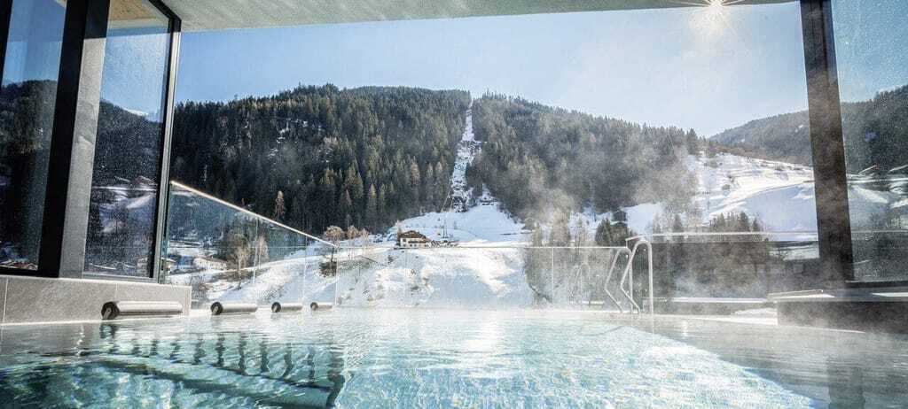 Im Außenpool des SeeMOUNT Wellnesshotel in Tirol hat man direkten Blick auf die Berge und kann dort nach dem Skifahren oder Wandern entspannen.