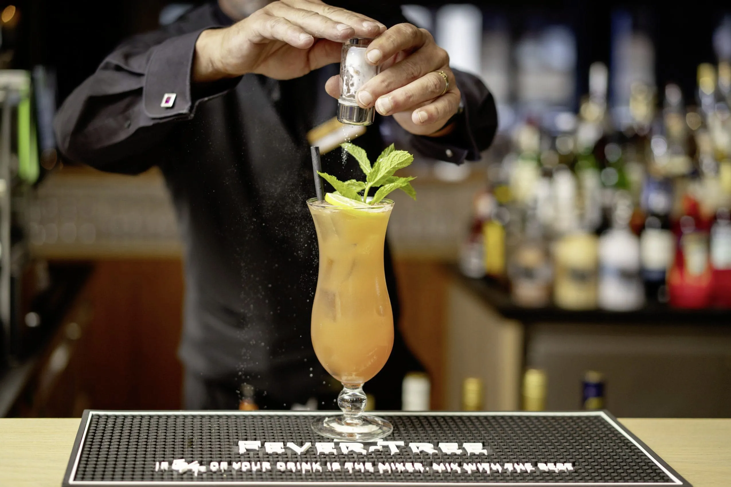 Leckerer Cocktail der an der Bar des Design- und Wellnesshotels Bergland von einem Barkeeper zubereitet wird.