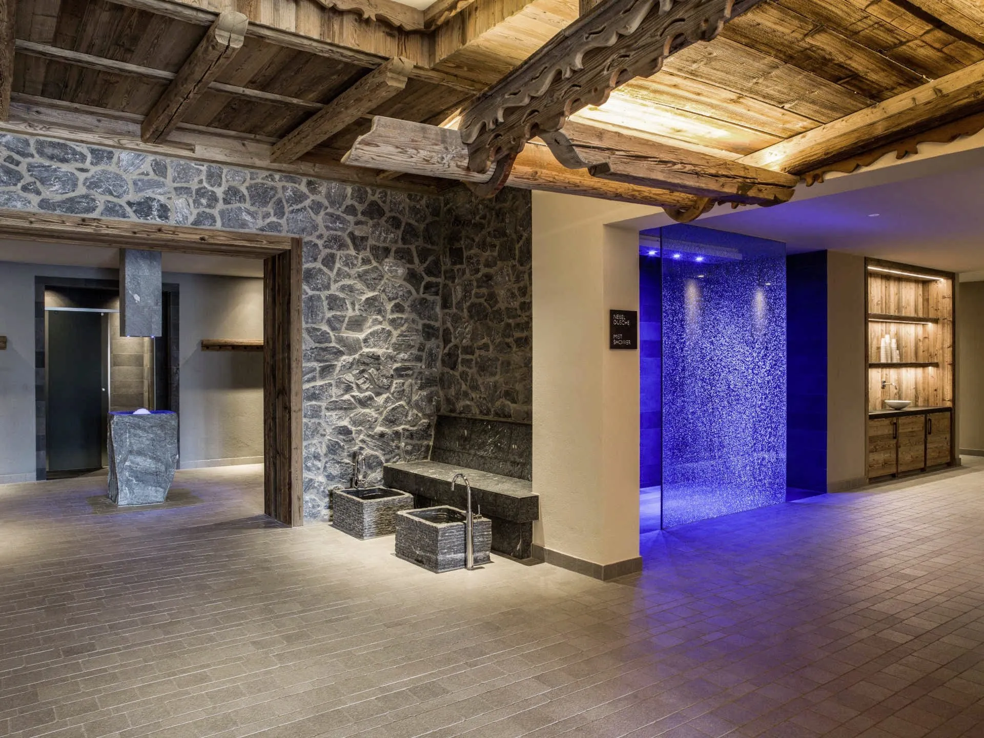 Das gro&szlig;z&uuml;gige Saunadorf des Interalpen Hotels mit vielen Holz- und Natursteinelementen.