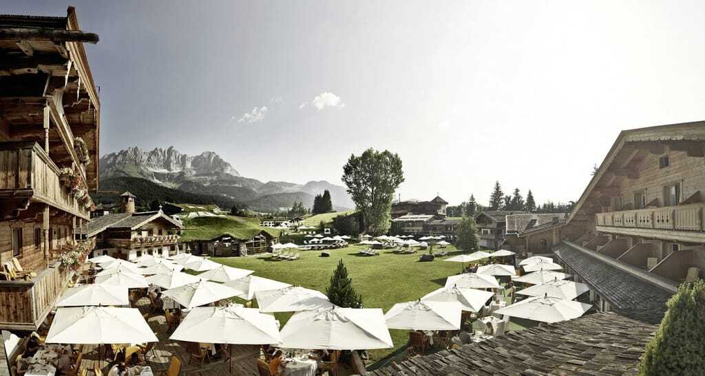 Urige rustikale Holzbalkone zieren das Wellnesshotel Stanglwirt. Eine weiträumige Terrasse und Liegewiese mit Sonnenschirmen und Liegen laden dazu ein die Seele baumeln zu lassen.