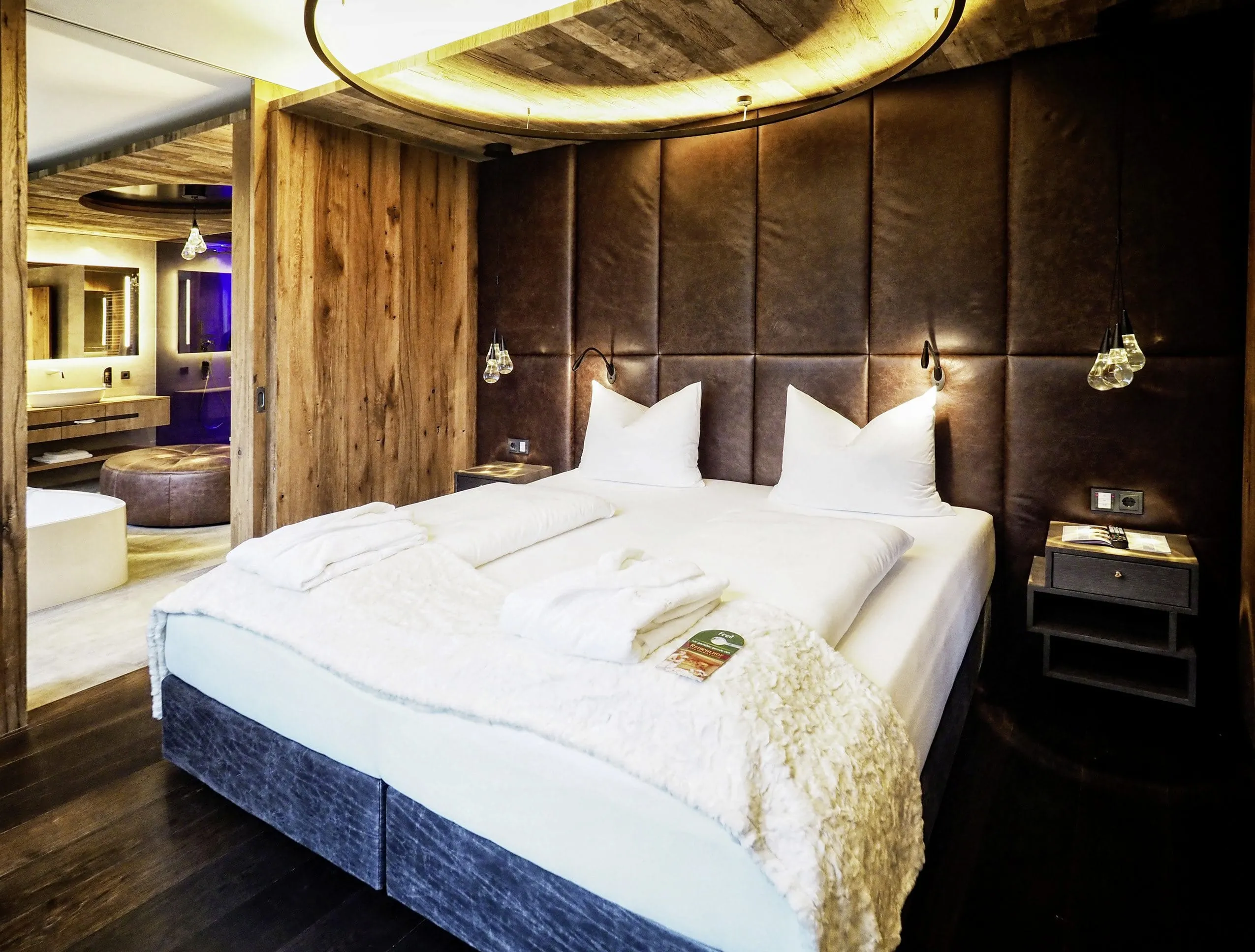 Schlafzimmer in der Private Wellness Suite im Wellnesshotel Reischlhof mit Doppelbett und Leder- und Holzausstattung