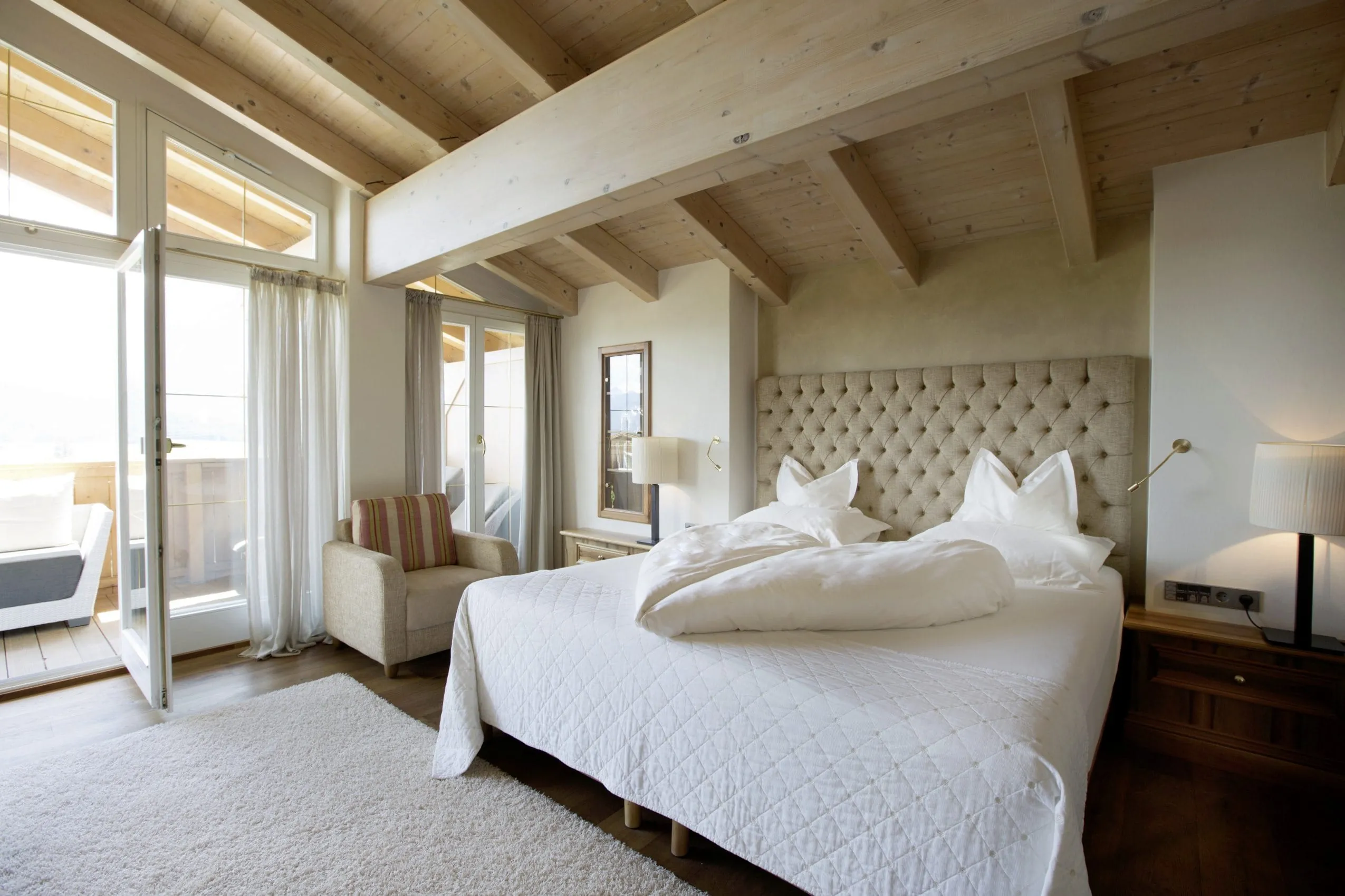 Schlafzimmer der Royal Garden Suite mit Doppelbett mit wei&szlig;en Laken und direktem Zugang auf den Balkon.