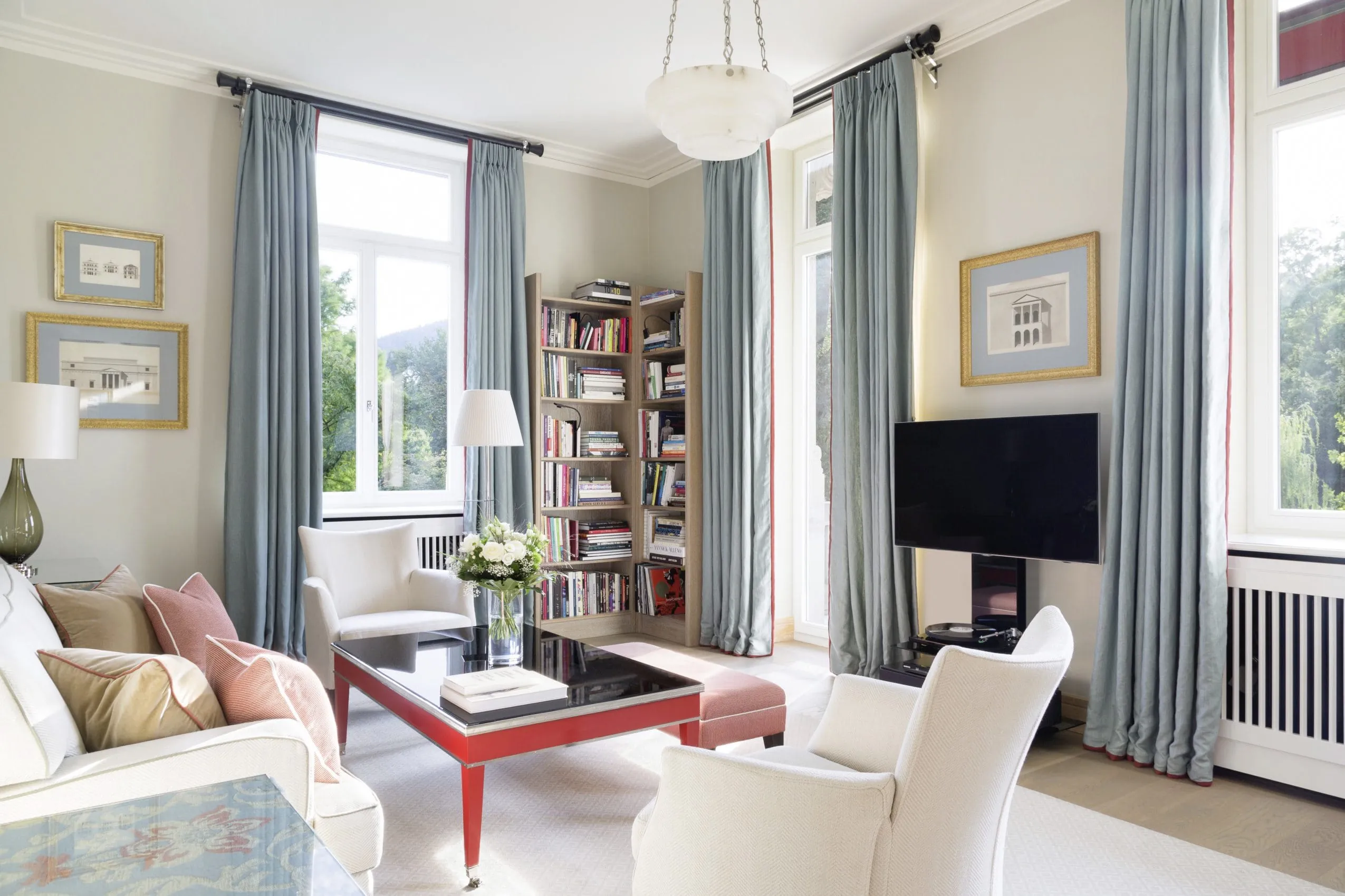 Wohnzimmer der Stephanie Spa Suite mit wei&szlig;en Polserm&ouml;beln und langen hellblauen Vorh&auml;ngen.