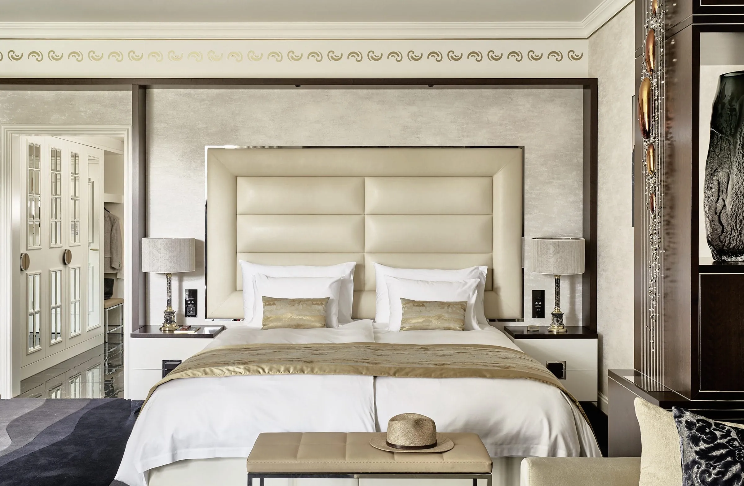 Luxuri&ouml;se Suite mit edler Tapete, Zierleisten und und gold-beigen Dekoelementen.