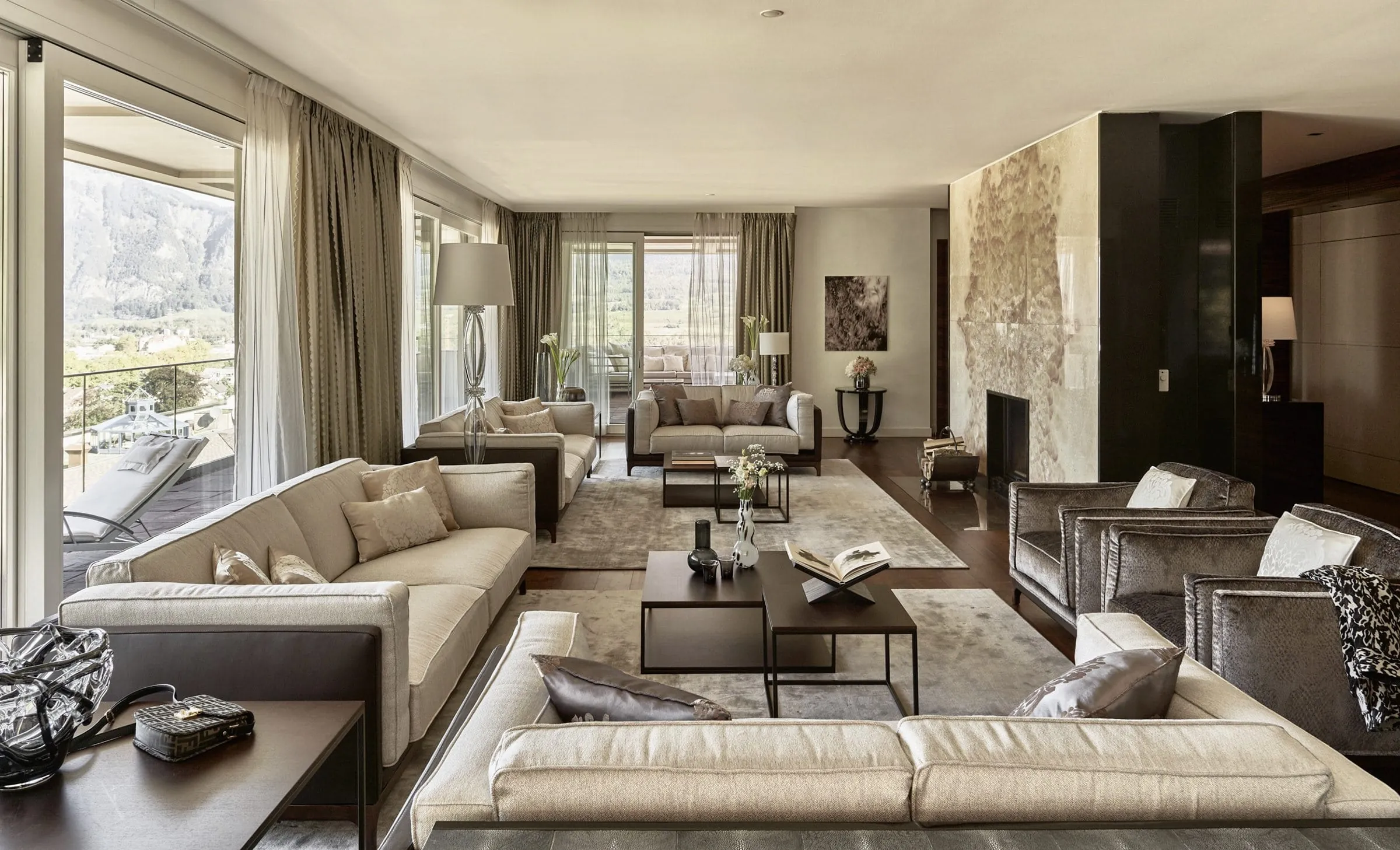 Gro&szlig;z&uuml;giges, luxuri&ouml;ses Wohnzimmer mit Kamin, zahlreichen Sofas und einem rundherum gehenden Balkon.