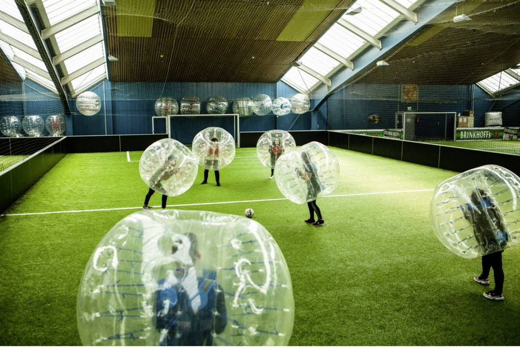 Kinder sind in einem durchsichtigen ballförmigen Anzug zum sogenannten Bubble-Socker. Eine unterhaltsame Unternehmung mit Kindern vor allem bei Regenwetter.