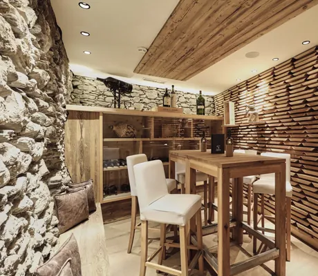 Weinlounge mit Bruchsteinwand und Hochtisch im Hotel Traube