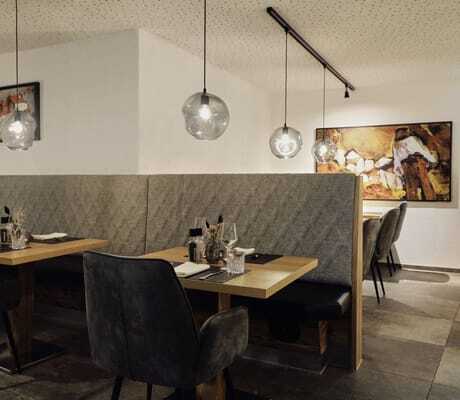 Restaurant im Hotel Traube mit grauen Raumtrennern und runden Hängeleuchten