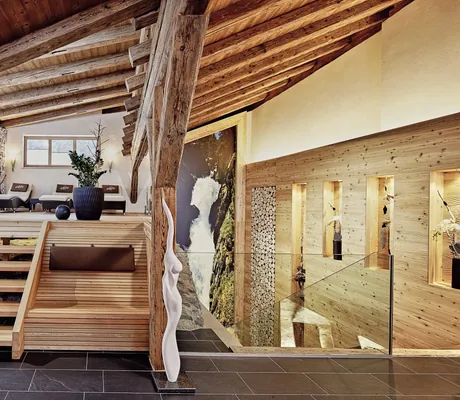 Treppe im Wellnessbereich unter dem Dach des Hotel Traube mit alten Holzbalken und weißer Skulptur