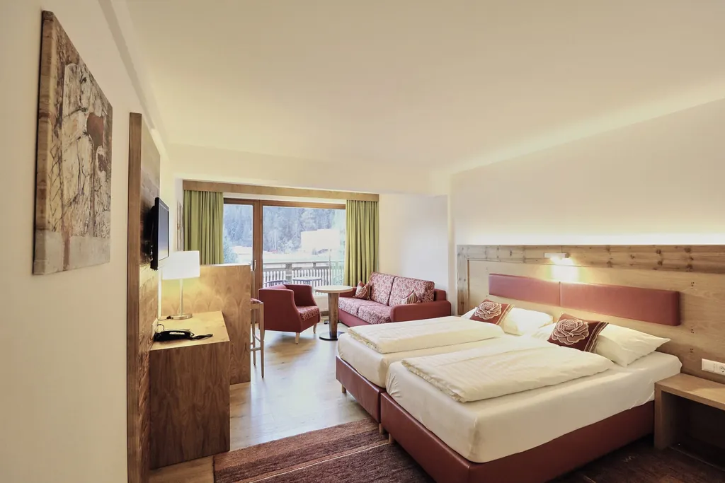 Zimmer im Hotel Traube mit rot umrandeten Bett und grünen Vorhängen