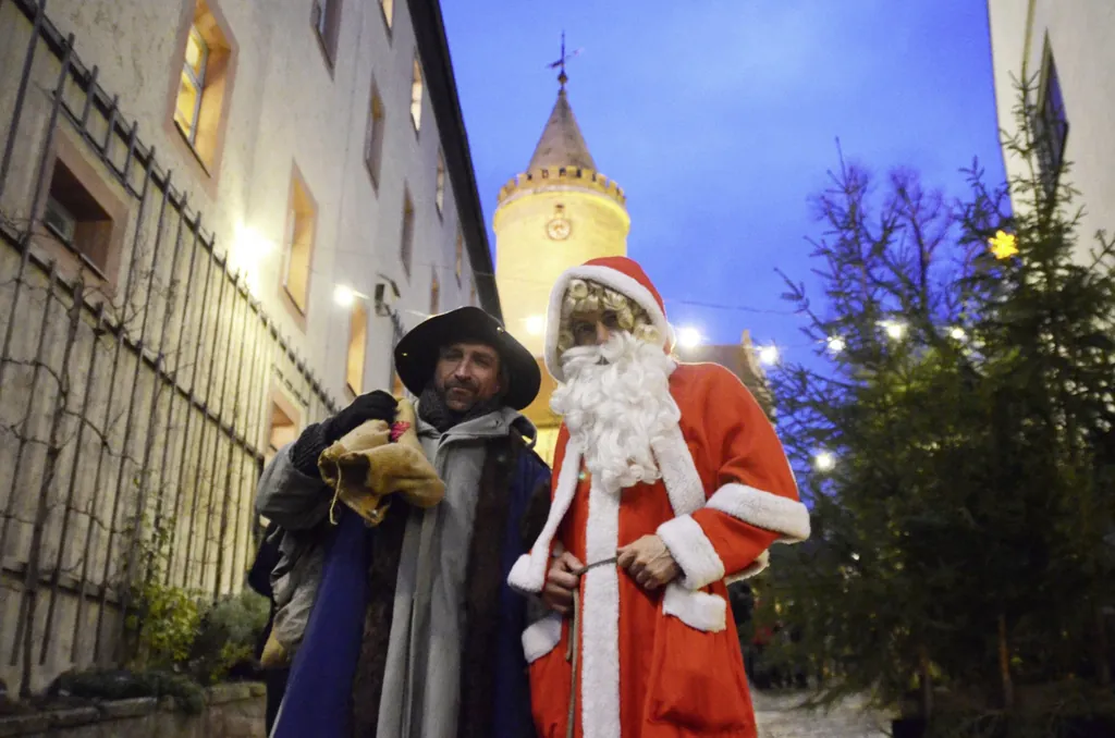 zwei M&auml;nner verkleidet als Weihnachtsmann und Knecht Ruprecht auf dem Gel&auml;nde der Leuchtenburg mit Turm im Hintergrund