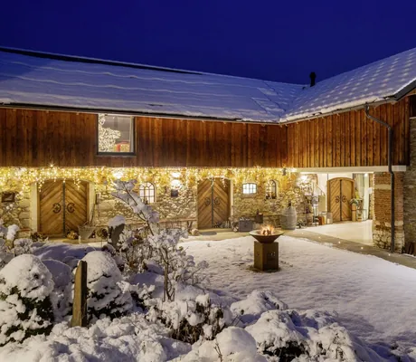 brennende Feuerschale im Schnee vor der Scheune der Golden Hill Chalets