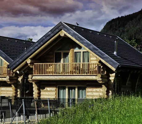 Außenansicht der Summit Lodges im Blockhaus-Stil mit großem Balkon und rot gefärbtem Himmel